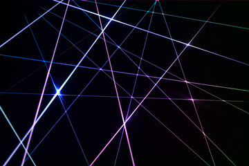 Intersecting glowing laser security beams on a dark background.Art design shine light ray.Laser field.