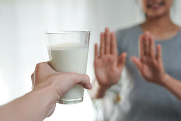 Woman refusing or reject glass of milk allergy lactose intolerance and health care concept