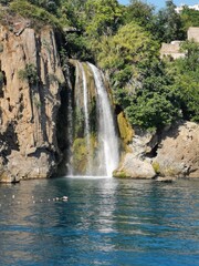 Fototapeta na wymiar A waterfall between the green and stones