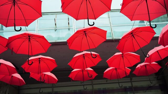 Belgrade, SERBIA - February 22, 2022: Red umbrellas instalation on city street. Town Attraction for tourist. Outdoor activity. Freedom travel in Europe.