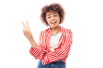 Positive friendly kazakh girl with afro hairstyle shows peace and love gesture wishes good luck to everyone isolated on studio background