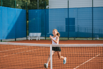 Girl in sportswear warming up on tennis court. Junior tennis player training for the competition.