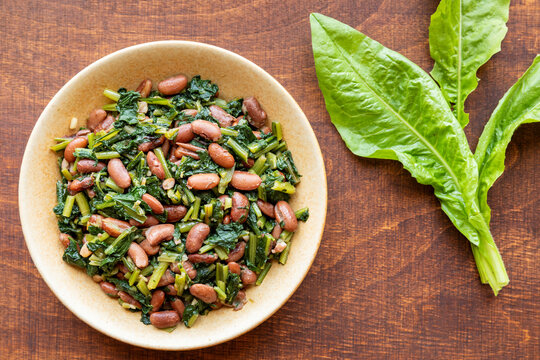 Famous Mediterranean dish with chicory leaves. Italian Cicoria e Fagioli (Chicory and beans). Borlotti beans aka cranberry beans aka  rosecoco.