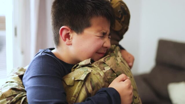 Veteran soldier greeting and hugging his son reunited after US army service - Family concept