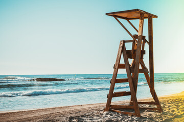 Sandy beach with lifeguard chair and clear blue sky.