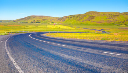 S-curved asphalt road leads to the mountains in volcanic area - İceland