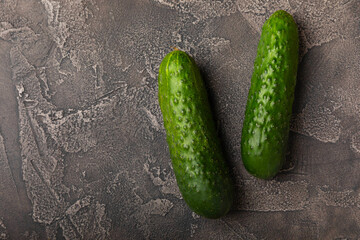 Fresh cucumbers on a white black texture background. Vegetarian organic vegetables.Ingredient for salad. Healthy food.Copy space.Place for text