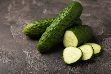 Fresh organic cucumbers against black marble background.Cucumber slices. Salad ingredient. Fresh vegetables. Vegan food. Healthy food. Fresh organic vegetables.
