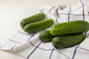 Fresh cucumbers on white texture wood. Vegetarian organic vegetables.Ingredient for salad. Healthy food.Copy space.Place for text