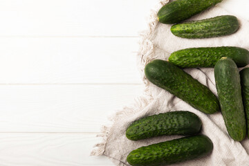 Fresh cucumbers on white texture wood. Vegetarian organic vegetables.Ingredient for salad. Healthy food.Copy space.Place for text