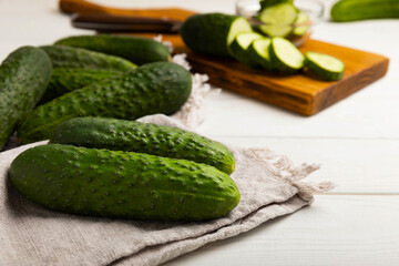 Fresh organic cucumbers on a white wooden table.Cucumber slices. Salad ingredient. Fresh vegetables. Vegan food. Healthy food. Fresh organic vegetables.