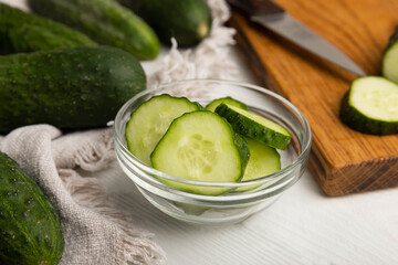 Fresh organic cucumbers on a white wooden table.Cucumber slices. Salad ingredient. Fresh vegetables. Vegan food. Healthy food. Fresh organic vegetables.