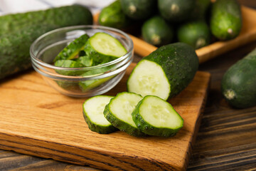 Fresh organic cucumbers on a brown wooden table.Cucumber slices. Salad ingredient. Fresh vegetables. Vegan food. Healthy food. Fresh organic vegetables.