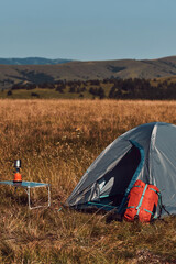 Camping in nature, unpacking and packing small tent outdoors, recreation and hobbies.