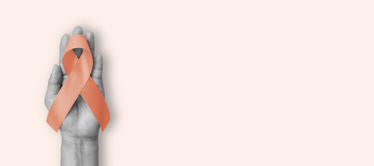 Uterine, Gynecologic aand Vaginal cancer awareness ribbon (isolated with clipping path) with peach bow on color background
