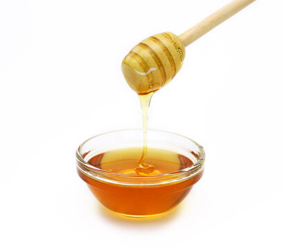 Wooden spoon with dripping honey on a white background. shallow depth of field