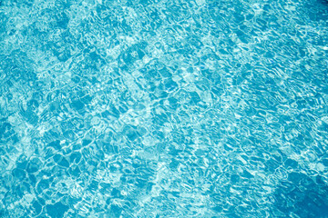 Transparent water in the pool with glare and waves, water abstract background. Vacation concept