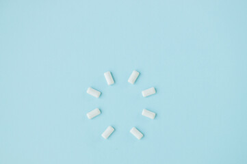 Top view of round shape from white chewing gums on blue background