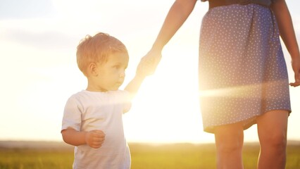 people in the park. mother and son walk at sunset in nature in the summer in the park. happy family a kid dream concept. mother and son holding hands in nature. lifestyle happy family together
