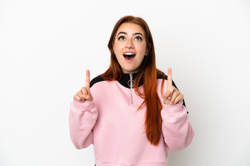 Young redhead woman isolated on white background surprised and pointing up - obrazy, fototapety, plakaty
