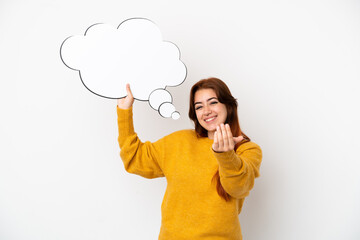 Young redhead woman isolated on white background holding a thinking speech bubble and doing coming gesture