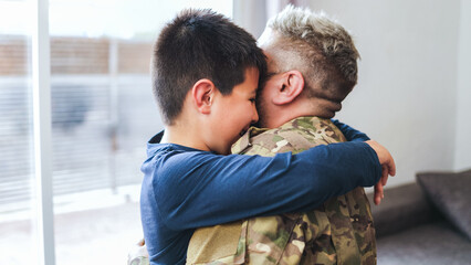 Veteran soldier greeting and hugging his son reunited after US army service - Family concept