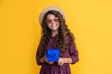 smiling girl with curly hair hold present box on yellow background