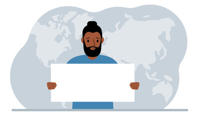 The concept of world attention. A man holds a white poster in his hands against the background of a world map.