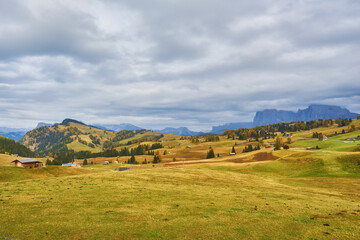 Beautiful sunrise view of meadow Seiser Alm Alpe di Siusi with Odle - Geisler mountain group on background. Morning autumn scenery in Dolomite Alps, Italy.