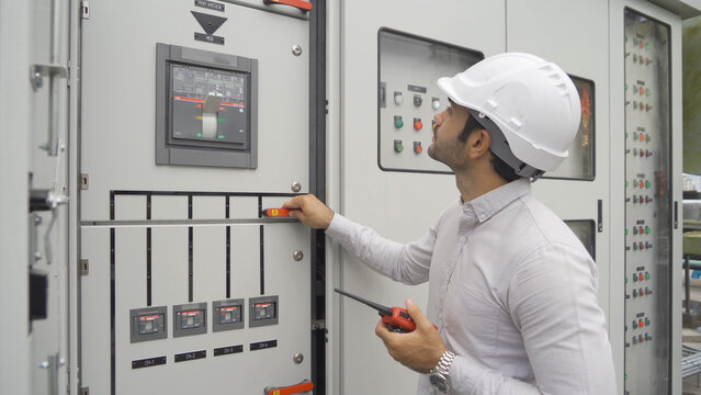 An engineer man or worker, people working in electrical room. Power energy motor machinery cabinets with panel in control or server room, operator station network in industry factory. Switchgear