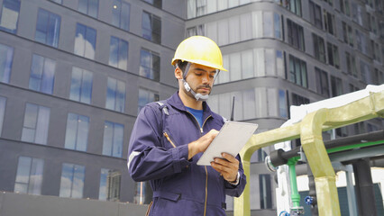 An engineer man or worker, people working in industry factory, using a tablet technology device on rooftop building. System work machine. Condenser Water Supply pipe lines. Workshop site.