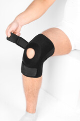 Knee Support Brace on leg isolated on white background. Elastic orthopedic orthosis. Anatomic braces for knee fixation, injuries and pain. Protective knee joint bandage sleeve. Trauma, rehabilitation