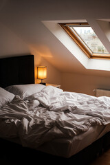 Scandinavian style bedroom with white bed and skylights