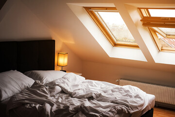 Scandinavian style bedroom with white bed and skylights