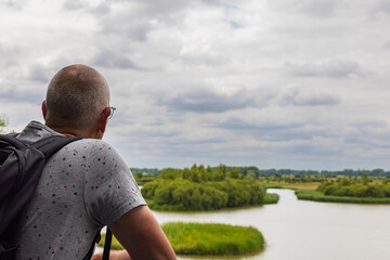 Male enjoying the view from viewing platform Amerongse Bovenpolder in Utrecht The Netherlands