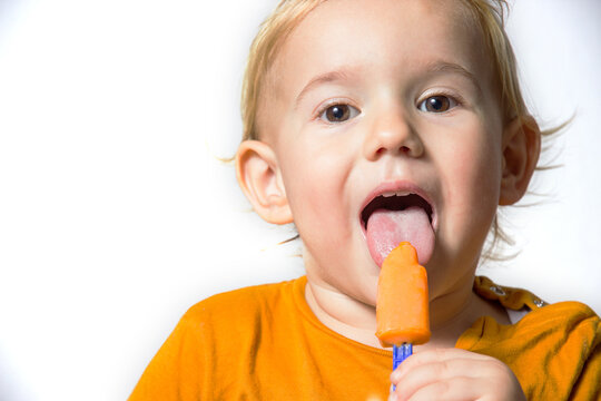 niño comiendo un helado de naranja