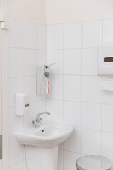 Public toilet cabin. Clean empty hospital washroom with a sanitizer or dispenser or alcohol solution for hand disinfection , close-up. Place for washing hands in the clinic. Medical Treatment room