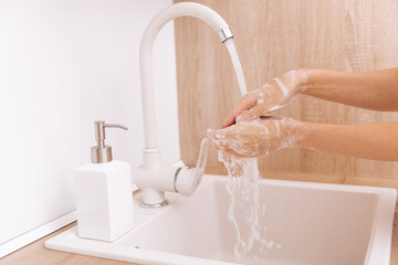 Washing hands under the flowing water tap. Washing hands rubbing with soap for corona virus prevention, hygiene to stop spreading corona virus in or public wash room. Hygiene concept hand detail