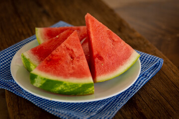 a plate of fresh watermelon with a blue napkin