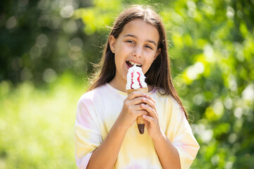 Beautiful little girl eats ice-cream in the summer