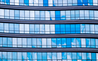 Reflection of sky in glass facade of office building