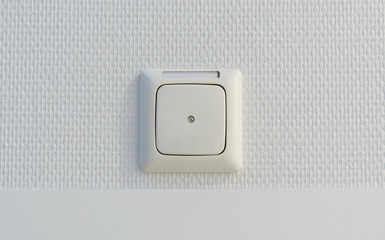 white light switch or electricity dummy box on a white wall