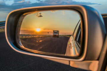 Fototapeta na wymiar Car mirror with beautiful sunset view