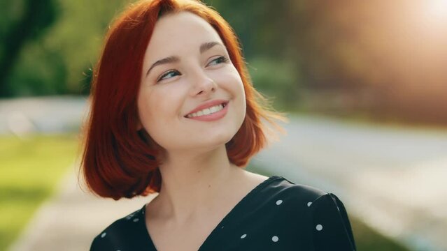 Inspired redhead female model woman attractive girl caucasian young lady inhaling fresh air make deep breath enjoying of blowing spring breeze looking at bright sun shining background fix hair smiling