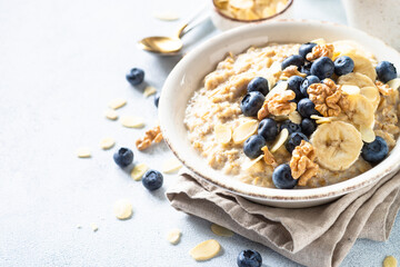 Oatmeal porrige in craft bowl at white background. Healthy breakfast.