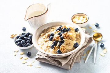 Oatmeal porrige in craft bowl at white background. Healthy breakfast.