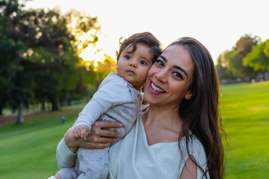 Hispanic mom and baby outdoors