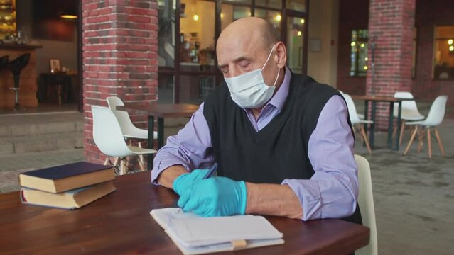 Old Male Teacher Works With Protective Mask And Gloves In University Canteen Or College Cafeteria