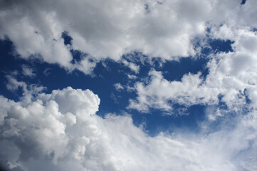 Obraz premium Natural background of white cumulus clouds on blue sky 