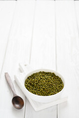 Mung bean in a white plate on a white wooden background